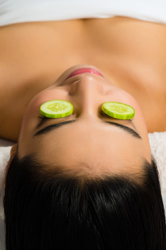 在美容spa接受面部皮肤护理的亚洲年轻女性