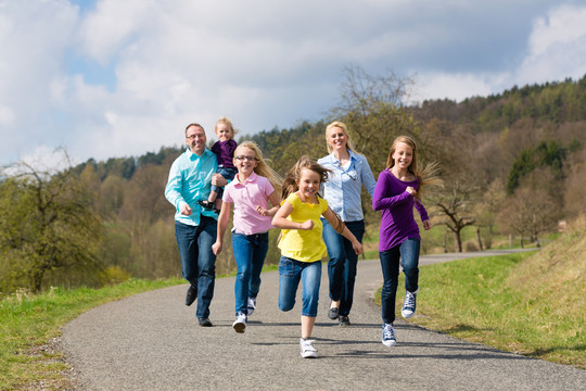 一家人（母亲、父亲和四个孩子）春天在户外跑步