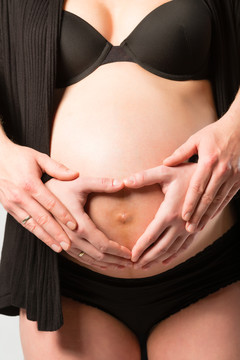 孕妇和男人轻轻抚摸她的小肿块或腹部