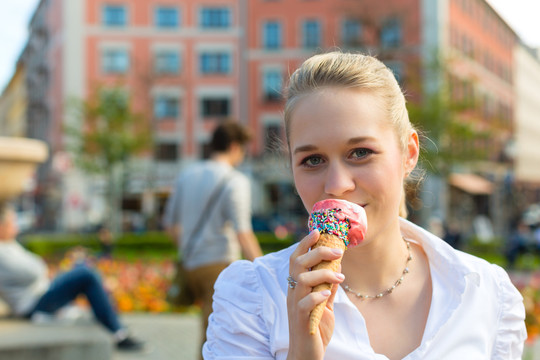 年轻女子在公园里吃冰淇淋蛋筒