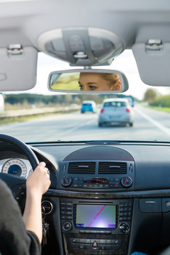 在高速公路上开车的年轻女子，从汽车内部看