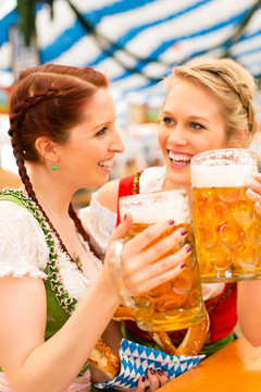 穿着传统巴伐利亚服装的年轻女性——迪恩德尔或特雷希特——在啤酒帐篷里参加节日或啤酒节