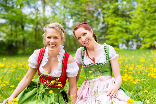春天，穿着传统巴伐利亚服装的年轻妇女在草地上
