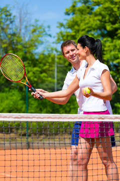 男子，网球运动老师，教女子如何在户外进行球拍运动