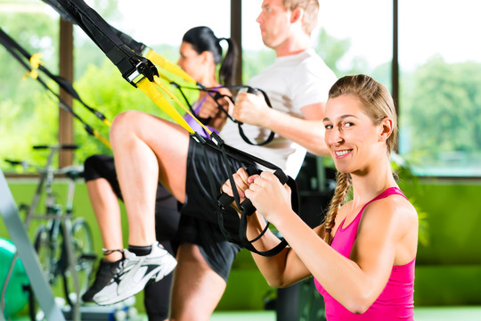 一群人在健身俱乐部或健身房用悬吊训练器锻炼