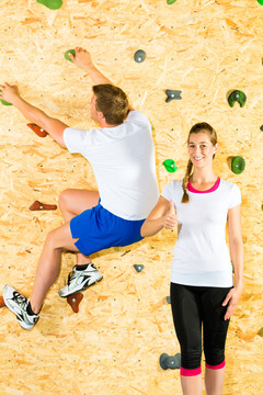 女子和男子攀岩在爬墙和训练身体