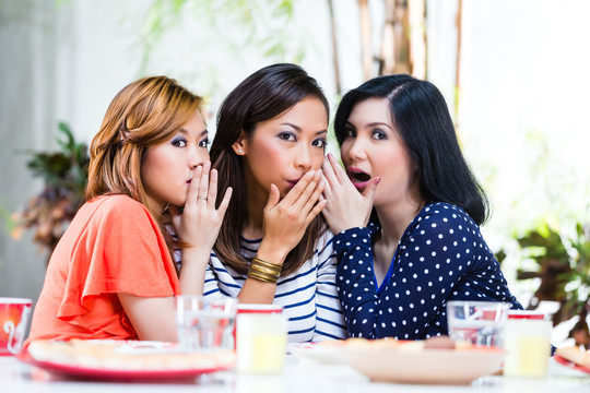 三个印尼朋友在热带环境中闲聊，窃窃私语