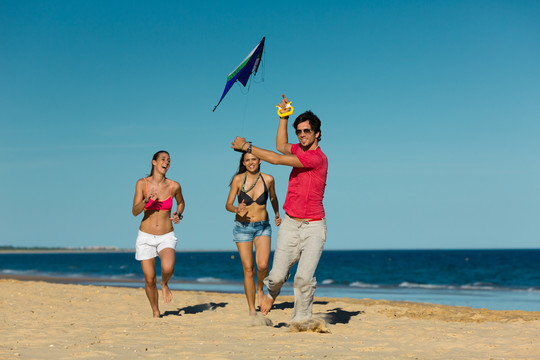 沙滩上放风筝的年轻人