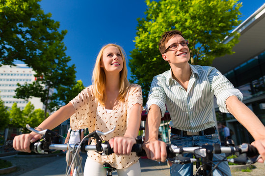 情侣-男人和女人-骑自行车或自行车在他们的空闲时间和乐趣在一个阳光明媚的夏日