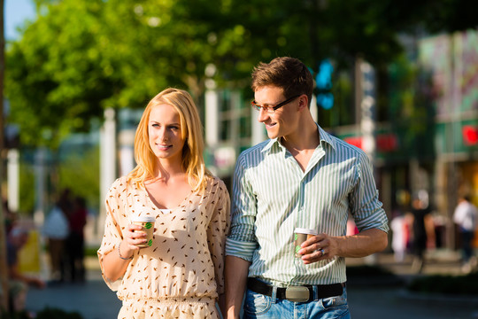 在阳光下散步的午休时间，一对夫妇在喝咖啡