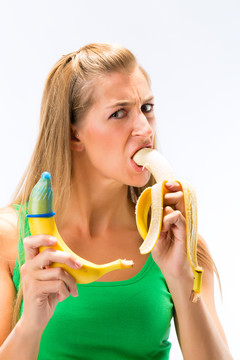 年轻女子吃香蕉的画像，展示另一个香蕉有避孕套