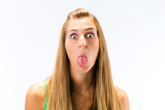 年轻女子在白色背景上伸出舌头戏弄的特写镜头