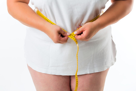 肥胖妇女用卷尺量腰围