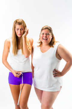 又瘦又胖的女人用卷尺量腰，一个女人看起来不开心或羡慕