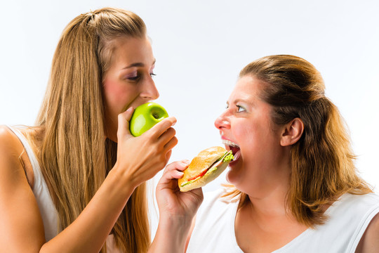 健康对抗不健康-瘦胖女人吃苹果和三明治