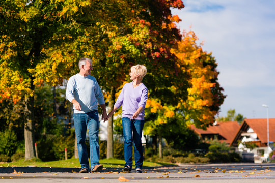 男人和女人，老年夫妇，秋天或秋天在户外散步，树上露出五颜六色的叶子