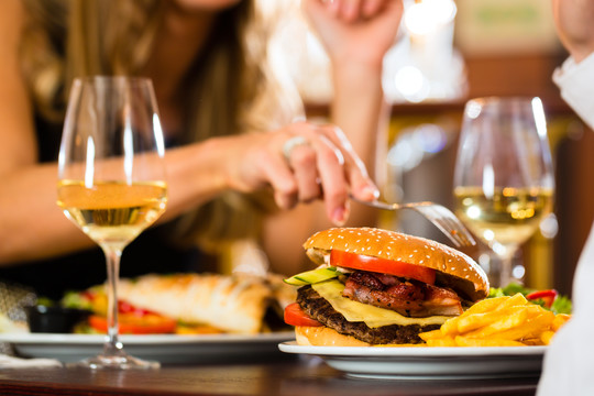 一对男女在一家高级餐厅里吃快餐、汉堡和薯条、特写镜头