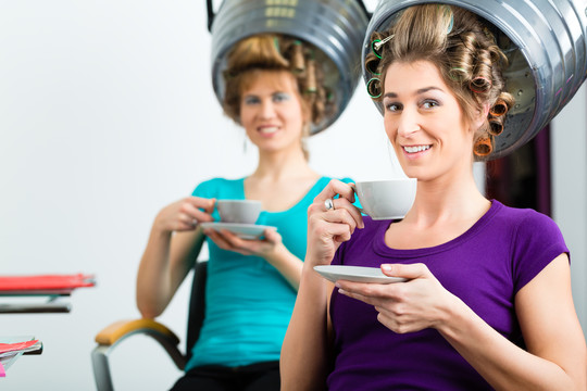 女人们在理发店喝咖啡或卡布奇诺聊天，而你的头发在吹风机下吹干