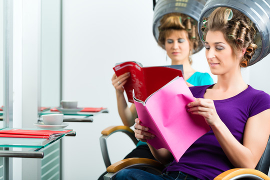 女人们在理发店看杂志或者拿抹布聊天，而你的头发在吹风机下吹干