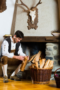 一个年轻人在传统的带壁炉的山间小屋里