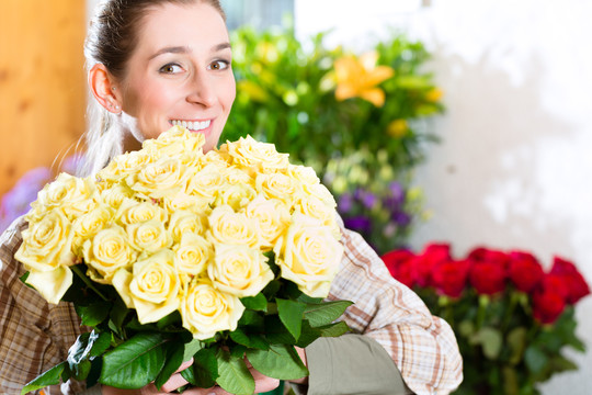 在花店或苗圃里献玫瑰的女花匠
