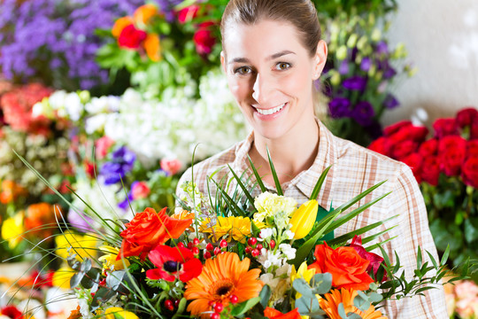 在花店或苗圃里献一束花的女花匠