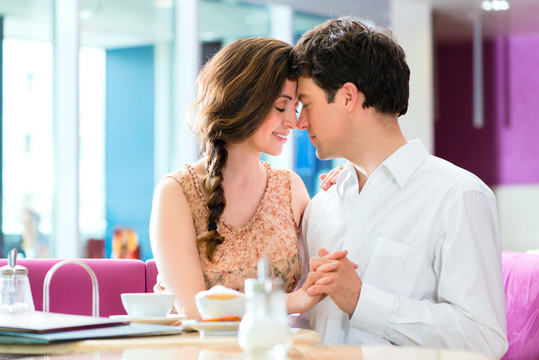 一对相爱的情侣在咖啡馆或冰淇淋店度过闲暇时间，一起拥抱亲吻