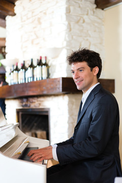 钢琴家在一家精致的餐厅里用钢琴营造出优美的音乐氛围
