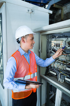 亚裔印尼技术人员或电工在施工现场或工厂对断路器箱或带电源线的开关箱进行功能试验验收
