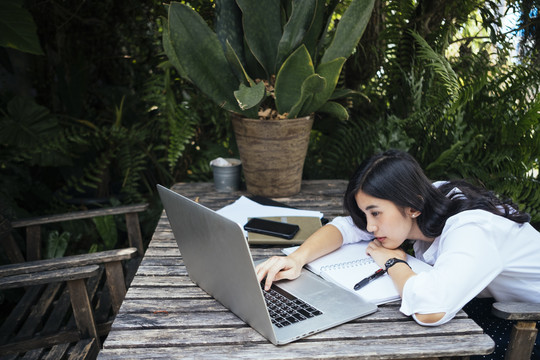 自由职业的亚洲女人厌倦了用笔记本电脑和疯狂的客户一起工作。
