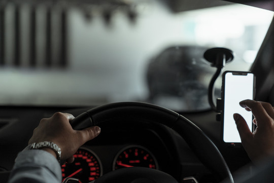 在汽车前玻璃上的导航装置的镜头，司机将目的地输入应用程序。