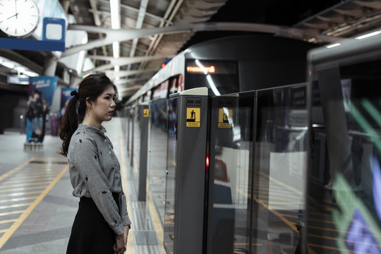 一名亚泰妇女站在大门口等火车停下。