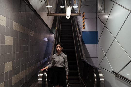亚泰女子在地铁站使用自动扶梯下楼梯。
