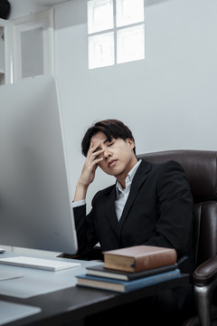 坐在办公室工作的椅子上累得不眠之夜。下班后筋疲力尽。