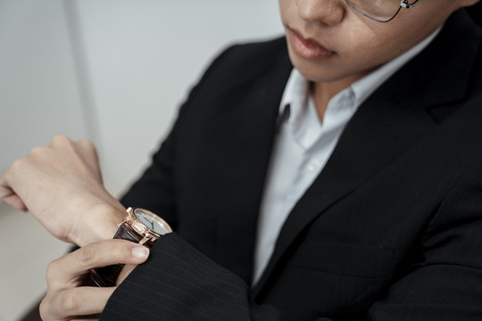 亚洲商人在看手腕上的手表。正在检查计划时间。