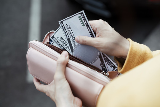 女人从钱包或皮夹里取现金的手，加速钱，买，买。