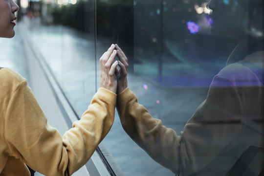 亚洲女人在街上摸镜子。另一个我自己照镜子。