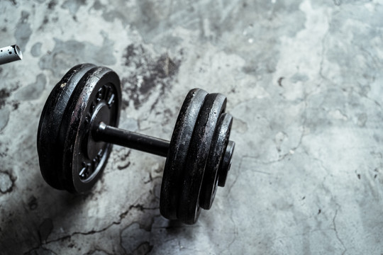 在户外或家里锻炼，在健身房的水泥地板上放一个笨重的哑铃。