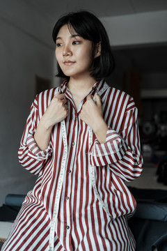 漂亮短发的亚洲女人对睡衣的梦想是成为一名时装设计师。