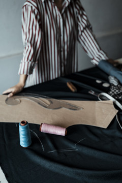 桌上的设计师配饰——准备做衣服的年轻亚洲设计师女士。