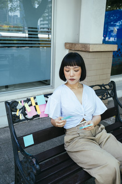一位亚洲女商人在粘纸上看清单。