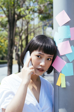 亚洲女商人黑色短发在户外打电话的画像。