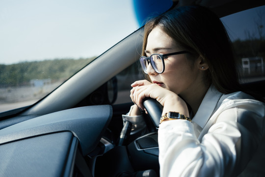 交通和车辆概念-特写泰国妇女戴眼镜在前排座位后转向。
