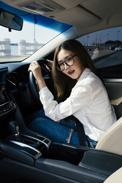 交通和车辆概念-戴眼镜的泰国妇女第一次驾驶汽车。
