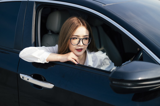 交通和车辆概念——车内戴眼镜的泰国妇女。侧视图。