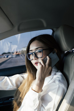 交通和车辆概念-戴眼镜的泰国女商人在车内打电话。