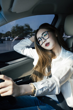 交通和车辆概念-泰国妇女戴眼镜和白衬衫驾驶汽车。