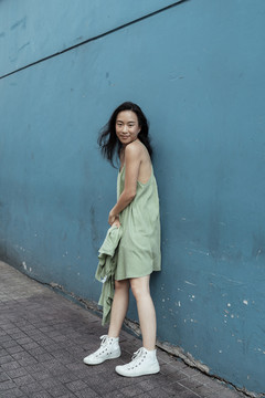 曼谷蓝色华尔街，一位年轻的泰国亚裔黑发女子身着绿色连衣裙。