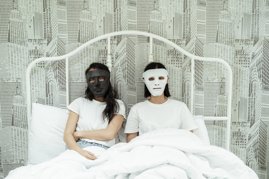 女同性恋者戴着面具睡在床上。