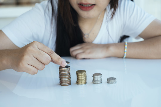 女人存钱时留下的一堆硬币的剪影。